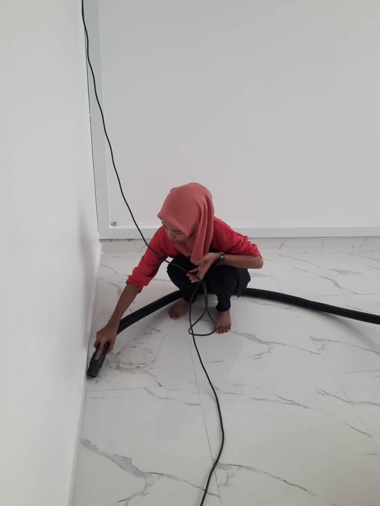 Krew Pink Mop membersihkan sudut dinding dengan vakum